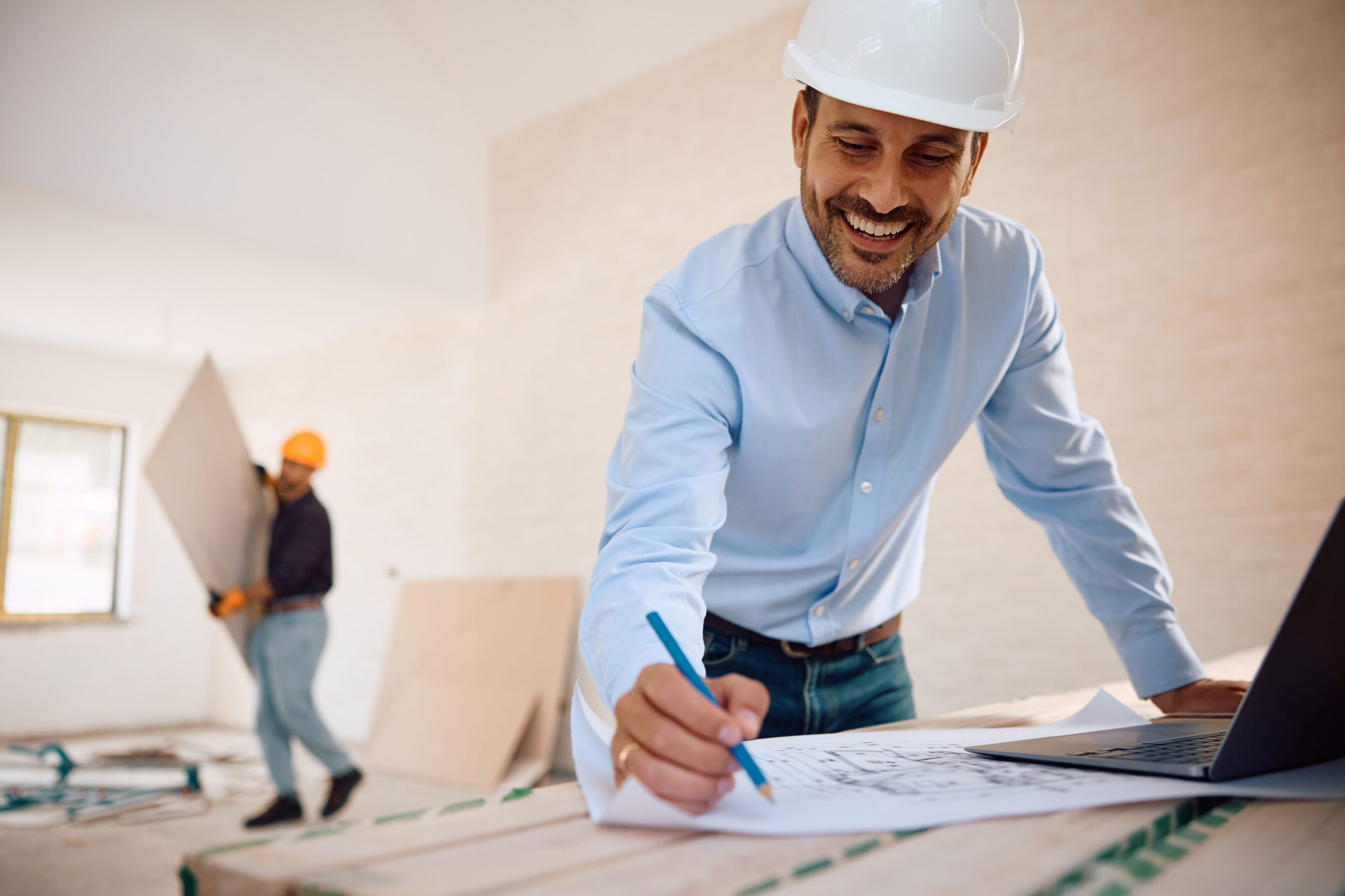 Smiling architect working on construction plans.