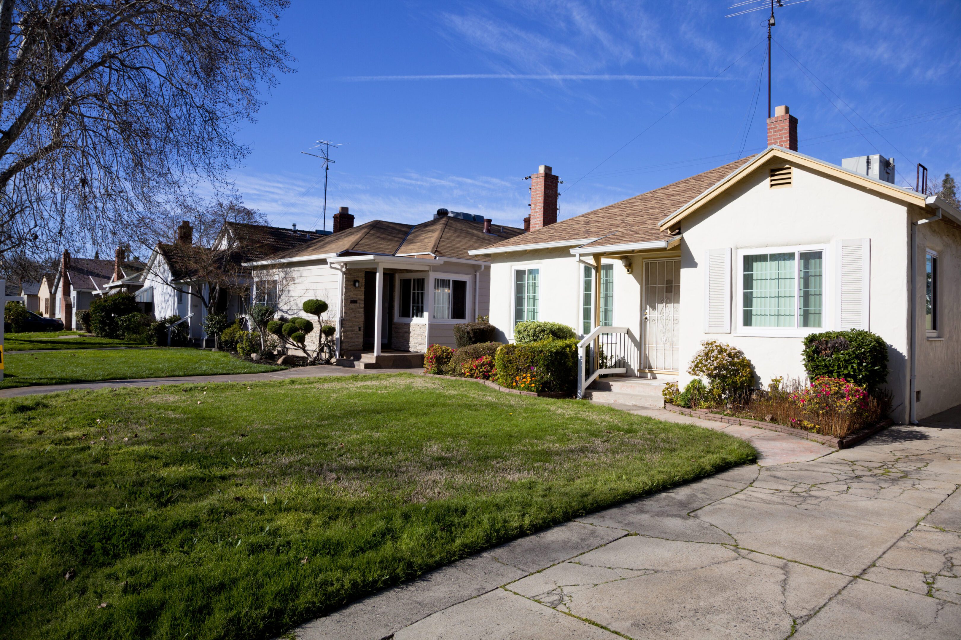 Suburban houses with green lawns and sidewalks.