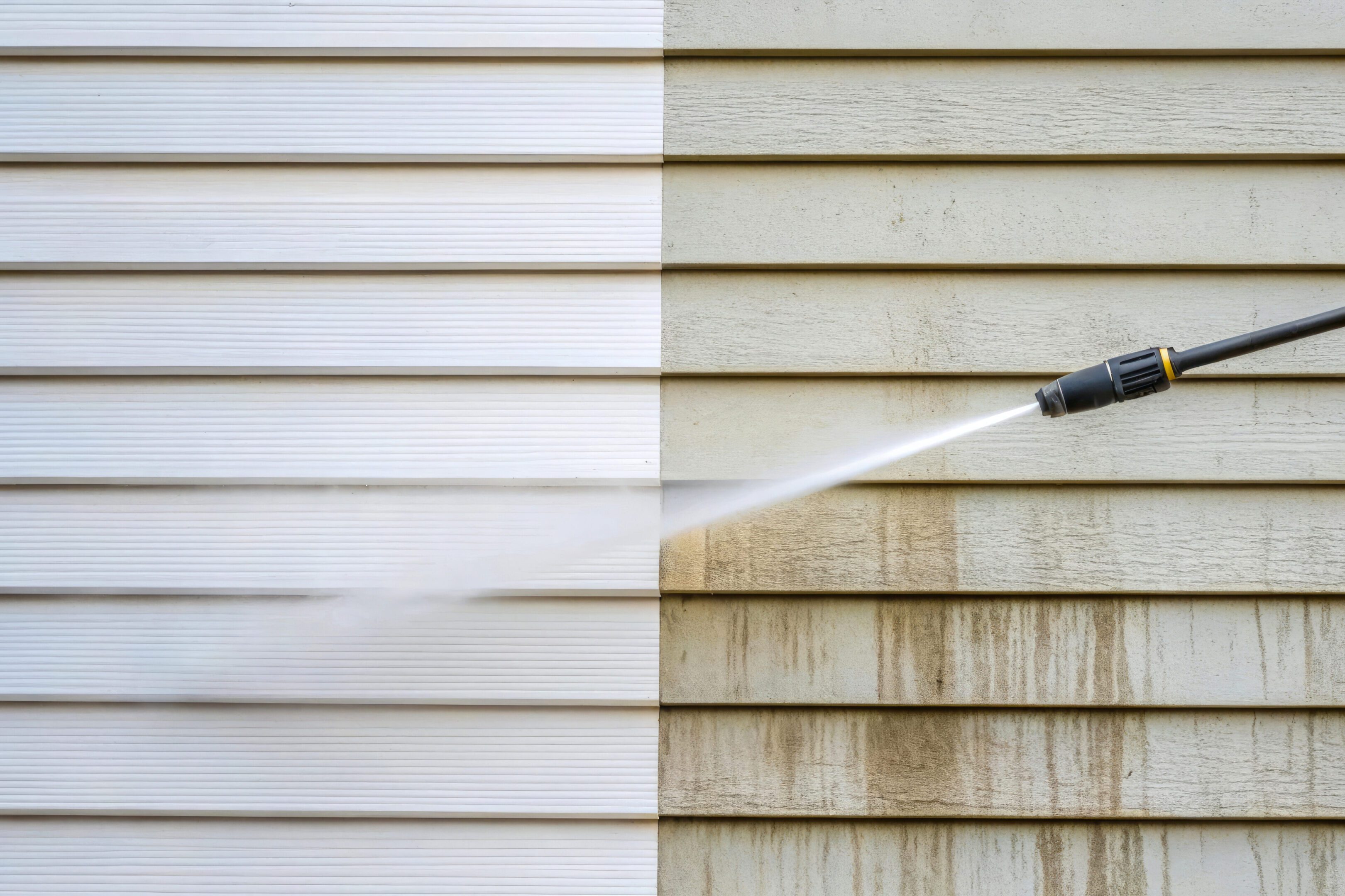 Pressure washing a house siding to clean dirt and grime using high pressure water spray for exterior wall cleaning and home maintenance Pressure washing a house siding to clean dirt and grime using high pressure water spray for exterior wall cleaning and home maintenance