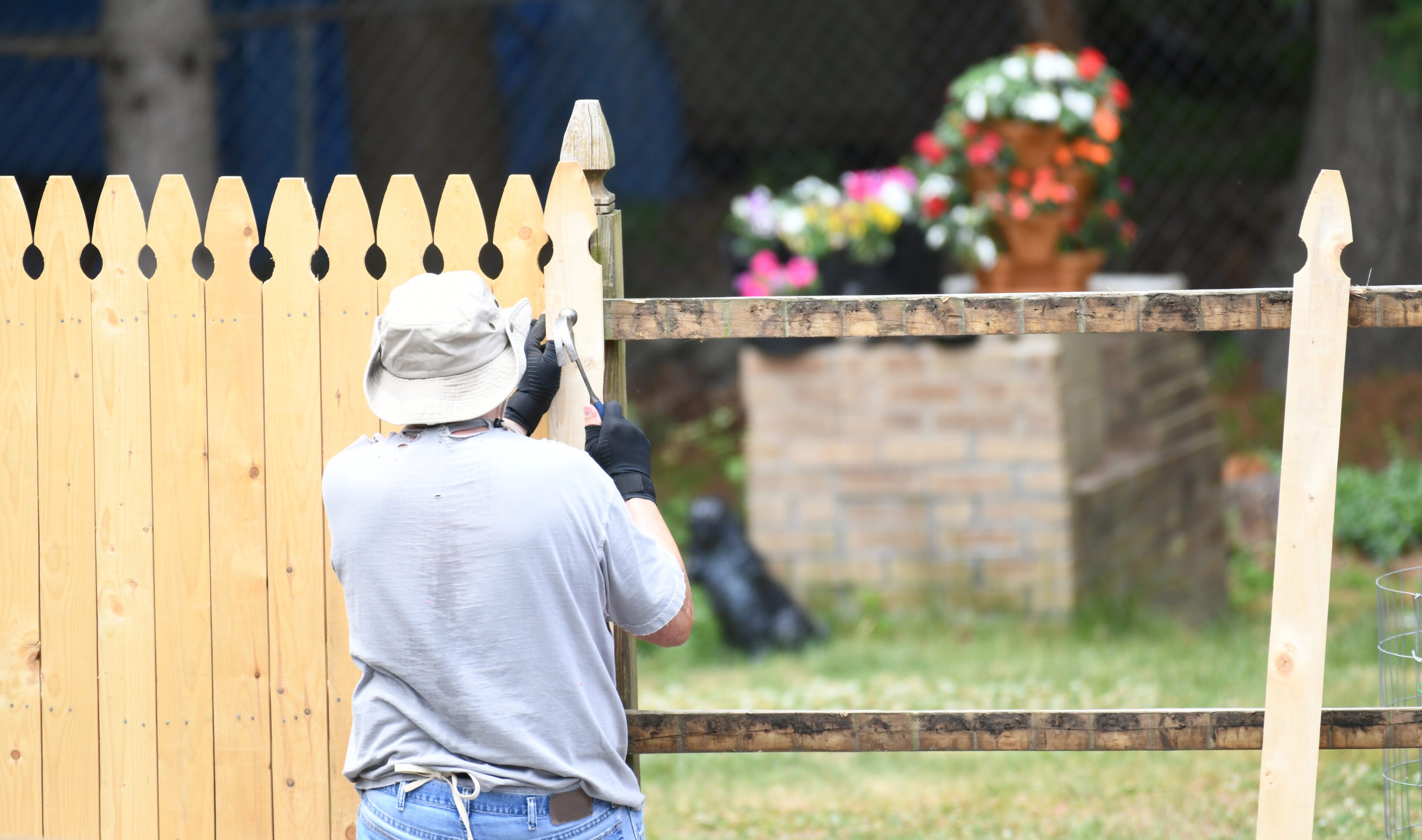 manual worker installing the wood fence in the yard manual worker installing the wood fence in the yard