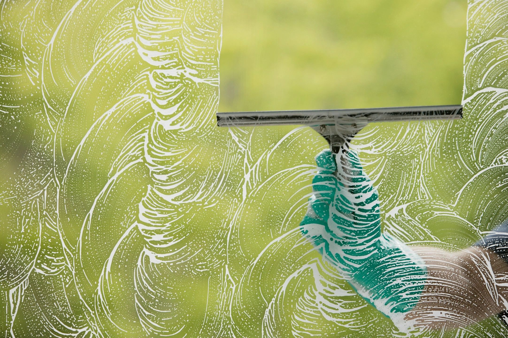 qtq80-n4aO8V A gloved hand cleaning a foggy window with a squeegee.